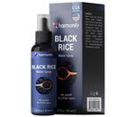 Eine lilafarbene Sprühflasche und die passende Schachtel für das Harmonify BLACK RICE Water Spray zur Förderung des Haarwachstums. Die Verpackung zeigt deutlich ein Bild von schwarzem Reis auf einem Holzlöffel und enthält den Hinweis „Proudly USA Company“ sowie die Zutatenliste an der Seite der Schachtel.