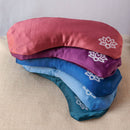 Ein Stapel von fünf farbenfrohen Seiden-Augenmasken mit einem weißen Lotusblumen-Design.