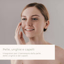 Eine lächelnde Frau mit heller Haut, die sanft ihre Wange berührt, mit einer Textüberlagerung zu „Pelle, unghie e capelli“ (Haut, Nägel und Haare) und Nahrungsergänzungsmitteln für das Wohlbefinden von Haut, Nägeln und Haaren.