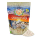 Eine Packung „Ancient Purity Diatomaceous Earth“ auf einem weißen Hintergrund, davor ein Haufen beigefarbenes Pulver.