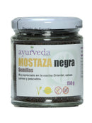 Ein Glasgefäß mit weißem Deckel, gefüllt mit kleinen schwarzen Senfsamen. Das Vorderetikett liest "Ayurveda autentico MOSTAZA negra Semillas", weist darauf hin, dass es "Muy apreciado en la cocina Oriental, salsas carnes y pescados" (sehr geschätzt in der orientalischen Küche, Saucen für Fleisch und Fisch) ist, und gibt "150 g" an