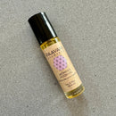 Nahaufnahme einer Roll-on-Flasche PAAVANI AYURVEDA Women's Moon Oil zur Unterstützung des weiblichen Zyklus, auf einer grauen Oberfläche.