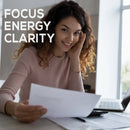  Eine lächelnde junge Frau mit lockigem Haar sitzt an einem Schreibtisch, hält ein Dokument und blickt zur Kamera, mit dem Text „FOKUS ENERGIE KLARHEIT“ im Vordergrund.