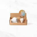 Eine kleine braune Papp-Geschenkbox mit einem rohen Stück weißem Geodenquarz und einem passenden Quarz-Pfeilspitzen-Anhänger an einer schwarzen Kordel, beschriftet mit „Gift of Clarity“ (Geschenk der Klarheit).