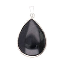 Ein tropfenförmiger Anhänger aus schwarzem Edelstein mit einer glatten, polierten Oberfläche. Der Stein ist in einer schlichten, silberfarbenen Metalfassung mit Öse für eine Kette eingefasst.