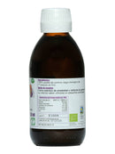 Das rückseitige Etikett einer braunen Glasflasche "Ayurveda autentico Comino negro Aceite Bio" (Schwarzkümmelöl). Es gibt "100% biologisches, kaltgepresstes Schwarzkümmelöl" als Zutat an und empfiehlt die Verwendung als Dressing in kleinen Mengen aufgrund seines intensiven Geschmacks.