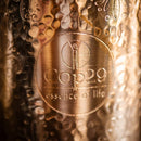 Nahaufnahme einer Kupferoberfläche mit gehämmerter Textur und eingraviertem „Cop29 essence of life“-Logo