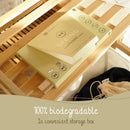 Eine Schachtel Cosmeau Spring umweltfreundlicher Waschmittelblätter auf einem Wäschekorb aus Holz, betont die 100% biologisch abbaubare Natur und die praktische Aufbewahrungsbox.