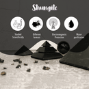 Infografik über den Schungit-Stein mit Pyramiden und Fragmenten, die seine Verwendung für wissenschaftliche Studien, EMF-Schutz und Wasserreinigung beschreibt.