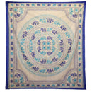 Ein rechteckiges Tuch mit einem zentralen Kreis aus blauen Elefantenmotiven und Mustern in Lila und Hellblau auf einem beigen Hintergrund, umrahmt von einem dicken blauen Rand.