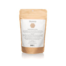 Die Rückseite eines stehenden Kraftpapierbeutels für Garshana-Handschuhe, mit weißem Text, dem PAAVANI AYURVEDA Logo und der Produktbeschreibung.