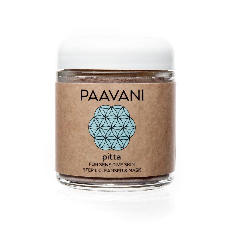 Eine lächelnde Frau mit lockigem, blondem Haar liegt entspannt auf einem Bett und hält eine Flasche "Paavani Tridoshic Facial Toner" in der Hand.