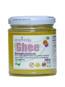 Ein Glasgefäß mit "Ayurveda autentico Ghee" (geklärte Butter) mit weißem Deckel und lila beschrifteter Vorderseite. Es wirbt mit 200 g, "BIO", "100% Natur", "Sin Gluten" und "OMG" (gentechnikfrei).