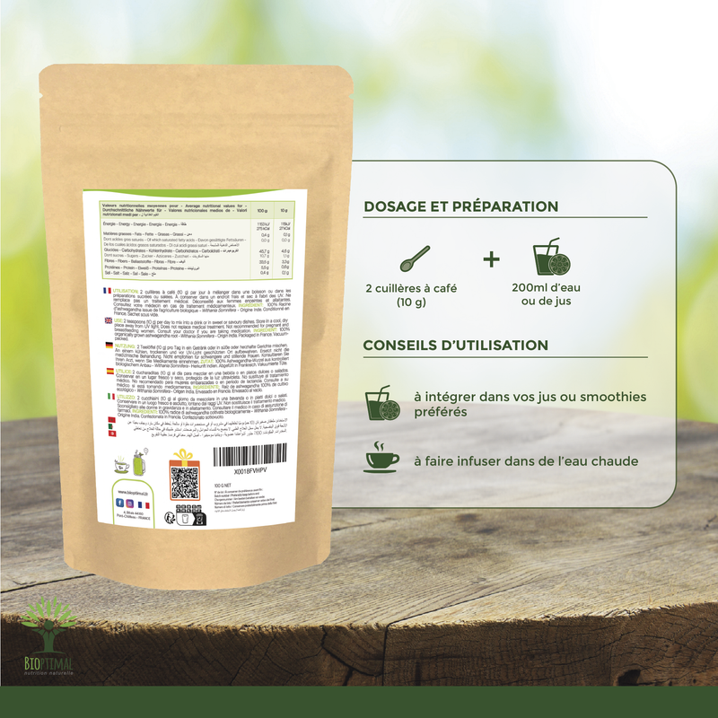 Rückansicht der 'Ashwagandha Bio'-braunen Papierverpackung mit detaillierten Nährwertangaben, Zubereitungshinweisen und QR-Code, auf einer Holzoberfläche mit grünem verschwommenem Hintergrund.