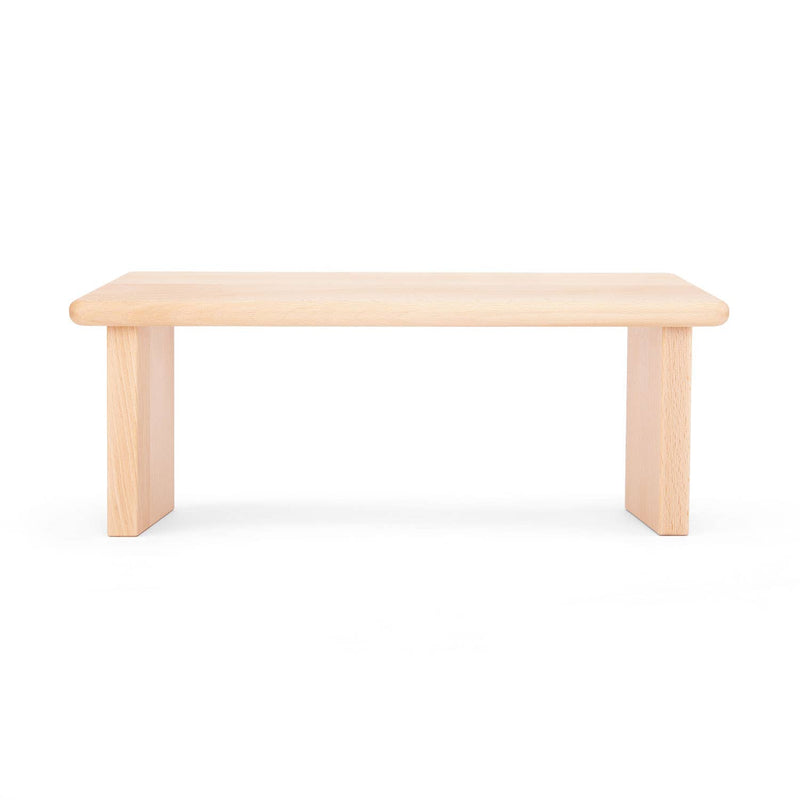 Meditationsbank aus hellem Holz mit glatter rechteckiger Sitzfläche und zwei vertikalen Beinen, auf weißem Hintergrund.