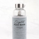 Eine transparente "myga" Wasserflasche mit einer grauen Stoffhülle und "Crystal Water Bottle myga" Aufschrift, stehend auf einer weißen Marmoroberfläche.