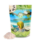 Eine Verpackung von "Ancient Purity Soursop Powder" mit einem Strandhintergrund. Die Verpackung zeigt Illustrationen der Soursop-Frucht an einem Baum und in einer Hand. Daneben liegt ein Haufen des hellrosa Pulvers.