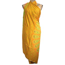 Ein orangefarbenes Sarong mit einem Pfauenmuster in Gelb und Grün, kunstvoll um eine Schaufensterpuppe drapiert, um als Strandtuch oder Überwurf zu dienen.