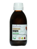 Eine braune Glasflasche mit weißem Schraubverschluss, beschriftet mit "Ayurveda autentico COMINO negro Aceite Bio" (Schwarzkümmelöl). Das Etikett zeigt ein grünes Blattmuster, "200 ml", "100% Natur", "Sin Gluten" und "OMG" (gentechnikfrei) Symbole.