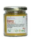Ein Glasgefäß mit "Ayurveda autentico Curry" aromatischem Gewürz, das 100 g enthält. Das Etikett hebt seine traditionelle Verwendung in ayurvedischen Behandlungen und in der Küche hervor und besagt, dass es "Eco Friendly", "Gluten Free" und "GMO Free" ist.