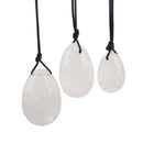 Ein Set aus drei glatten, polierten weißen oder klaren Steineiern in verschiedenen Größen, die jeweils an einer schwarzen Schnur hängen.