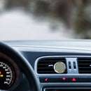 Runder Auto-Diffusor-Clip mit Blume des Lebens-Muster an einem Lüftungsschlitz im Auto befestigt.