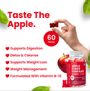 Eine Hand hält einen roten Gummibären, im Vordergrund eine Flasche Harmonify Apfelessig-Gummibärchen (60 Stück). Text hebt Vorteile hervor wie "Unterstützt die Verdauung", "Entgiftung & Reinigung", "Unterstützt Gewichtsverlust & Gewichtsmanagement" und "Formuliert mit Vitamin B-12".