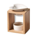 Eine Aromalampe aus Bambusholz mit einer herzförmigen weißen Keramikschale und einem unteren Keramik-Teelichthalter, isoliert auf weißem Hintergrund.