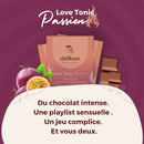 Ein romantisches Werbebild für die delikao „Love Tonic Passion“ 71% Zartbitterschokolade, das drei Tafeln, einen Stapel Schokoladenquadrate und Passionsfrüchte vor einem lila Hintergrund zeigt. Der französische Text wirbt für ein sinnliches Erlebnis: „Du chocolat intense. Une playlist sensuelle. Un jeu complice. Et vous deux.“