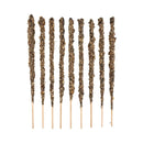 Eine Reihe von neun dicken, handwerklichen Räucherstäbchen vor weißem Hintergrund. Sie sind stark mit einer strukturierten, dunkelbraun-grünen Mischung aus getrockneten Kräutern und Harzen auf dünnen Holzsockeln bedeckt.