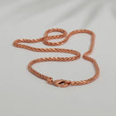 Eine geflochtene Kupferkette mit Karabinerverschluss, liegend auf einem weißen Hintergrund.