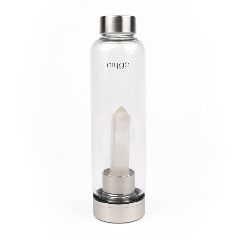 Eine durchsichtige Glaswasserflasche mit einem Edelstahldeckel und -boden, in der sich ein großer, klarer Quarzkristall befindet. Der Markenname "myga" ist auf der Flasche sichtbar.
