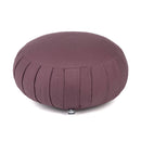 Draufsicht auf ein pflaumenfarbenes rundes Meditationskissen mit plissierten Seiten und kleinem Logo-Etikett, auf weißem Hintergrund.