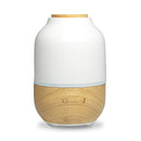 Einzelaufnahme eines Aroma-Diffusors aus Holz und weißer Keramik mit hellblauem Licht.