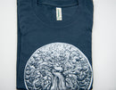 Ein gefaltetes, marineblaues T-Shirt mit einem weißen Aufdruck eines großen, knorrigen Baumes mit dichtem Blätterdach, der einem Gehirn ähnelt.