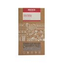 Eine braune Pappverpackung von "Manufaktur Salvia Hispanica L. Chia Weiss Chia Blanche" (350 g, Bio & Fair), mit einer transparenten Aussparung, die die weißen Chiasamen zeigt, und Symbolen für Fair Trade, handgemacht, Bio und glutenfrei.