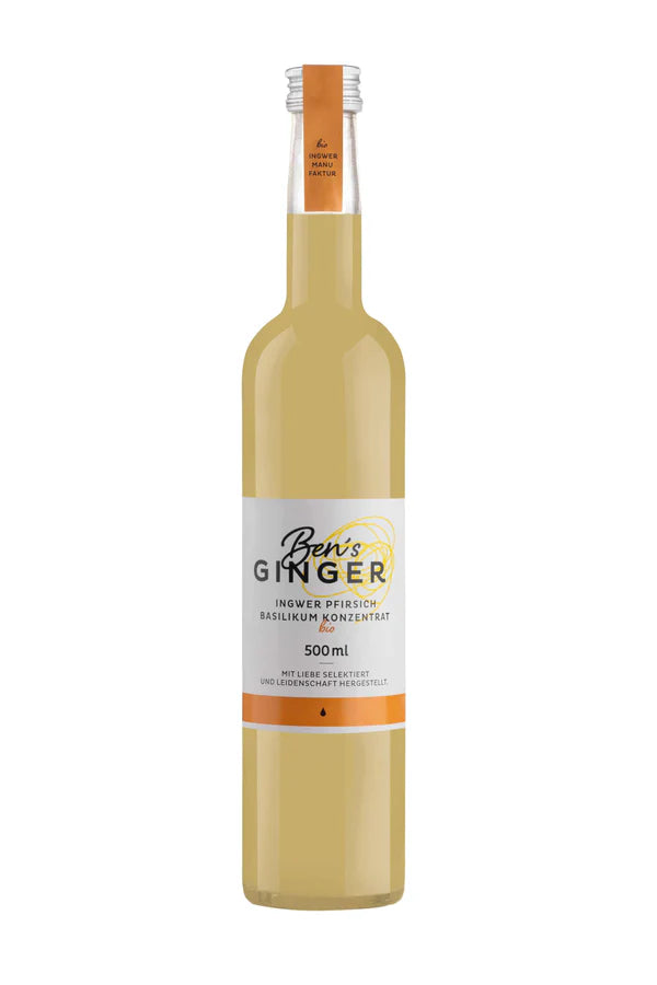 Eine Flasche "Ben's Ginger" mit weißem Etikett und orangefarbenem Verschluss, die eine trübe hellgelbe Flüssigkeit enthält. Das Etikett trägt die Aufschrift "Ingwer Pfirsich Basilikum Konzentrat" und "500ml".
