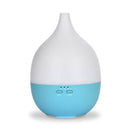 Ein weißer und hellblauer tropfenförmiger elektrischer Aroma-Diffusor mit Tasten für Nebel und Licht, vor einem einfachen weißen Hintergrund.
