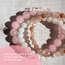 Drei Armbänder aus hellen, steinernen Perlen.