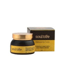 Ein schwarzer Tiegel Soul Tree Rejuvenating Cream mit goldenem Deckel steht neben der passenden gelb-schwarzen Verpackung.