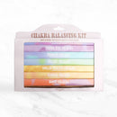 Eine weiße Chakra Balancing Kit Box von Myga, die sieben farbige, gestapelte Päckchen mit Räucherstäbchen enthält, die jeweils einem anderen Chakra zugeordnet sind.