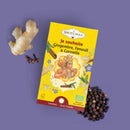 Schachtel Shoti Maa „Je souhaite“ Ingwer, Fenchel & Zimt Tee umgeben von Ingwer, Nelken und schwarzem Pfeffer.