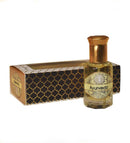 Kleines Glasfläschchen mit gelbem ätherischem Öl und der Aufschrift „Ayurveda“ neben seiner schwarz-gold gemusterten Präsentationsbox vor weißem Hintergrund.