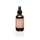 Eine braune Sprühflasche "PAAVANI AYURVEDA ROSE WATER soothing aromatherapy" (4 fl. oz.) auf weißem Hintergrund, mit einem geometrischen Muster und rosa Schriftzug.