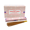 Eine Packung und Schachtel SATYA „Positive Vibes“ Räucherstäbchen, hergestellt von Shrinivas Sugandhalaya (BNG) LLP, zusammen mit mehreren braunen Räucherstäbchen.