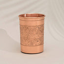 Ein einzelner, glänzender Kupfer-Becher oder -Glas mit einem detaillierten geprägten Muster aus Kreisen und Blumenmotiven.