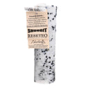 Eine schwarz-weiß gesprenkelte Kerze mit einem Papieranhänger.