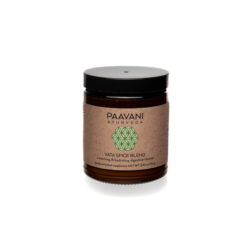  Ein kleines braunes Glasgefäß mit schwarzem Deckel steht vor weißem Hintergrund. Das Etikett trägt die Aufschrift "PAAVANI AYURVEDA" mit einem grünen geometrischen Design und "VATA SPICE BLEND, eine wärmende & feuchtigkeitsspendende verdauungsfördernde Churna, pulverisiertes Kräuterergänzungsmittel, NETTOGEWICHT 2.47 oz (70g)".