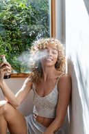 Hände, die PAAVANI TENSION RELIEF OIL aus einer Rollerflasche auf den Handrücken auftragen.