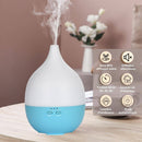 Ein elektrischer, weiß-blauer tropfenförmiger Aroma-Diffusor, der Nebel ausstößt, mit einer französischen Funktionsübersicht, die auf geräuschlose Diffusion und einen Timer hinweist.